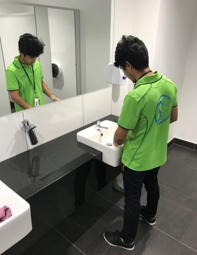 Janitor cleaning restroom sink for hygiene and sanitation