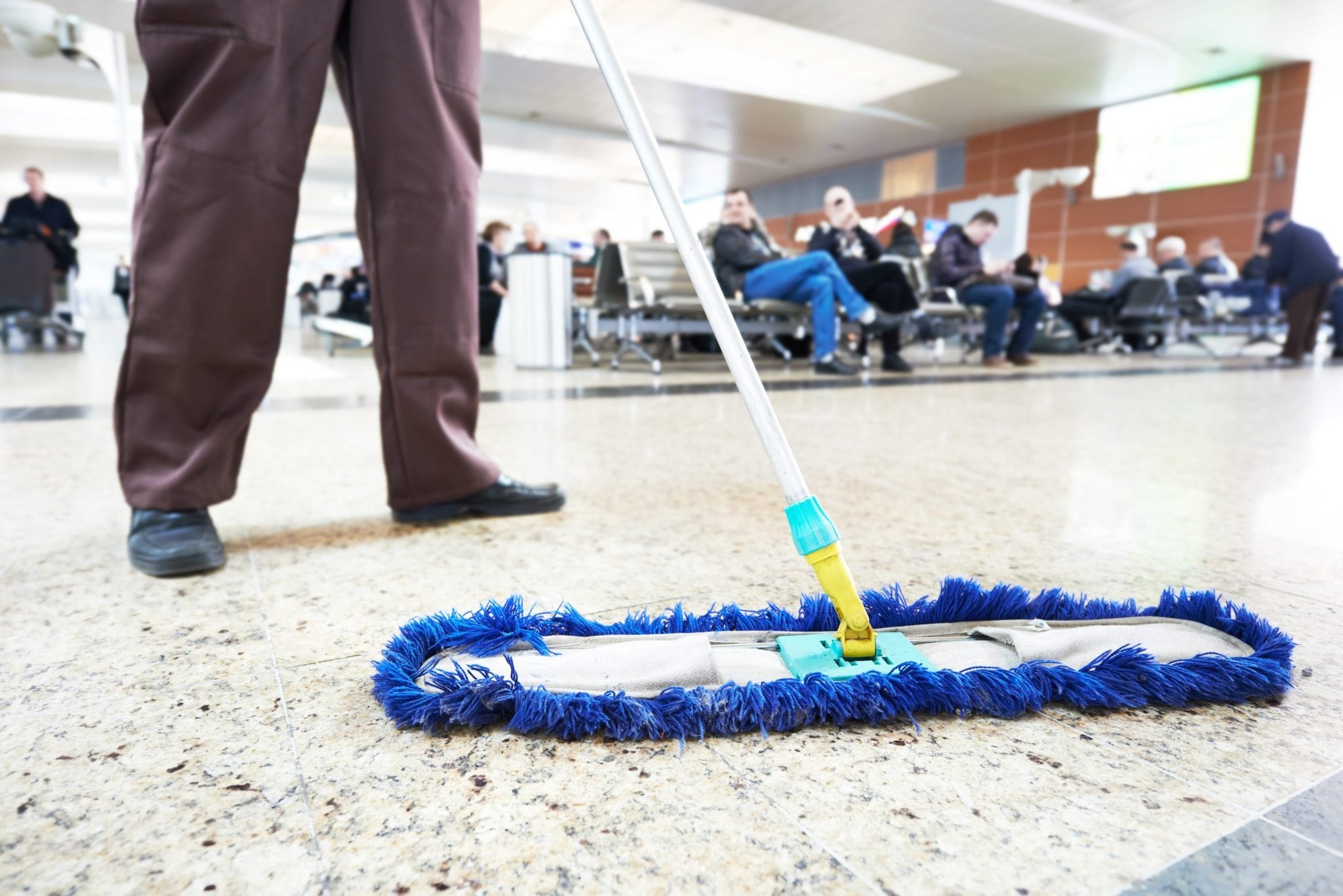 Professional janitor mopping an airport floor for cleanliness and hygiene